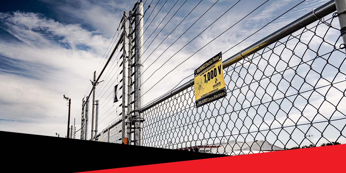 A Chain Link Fence With a Sign That Says 7000V on It