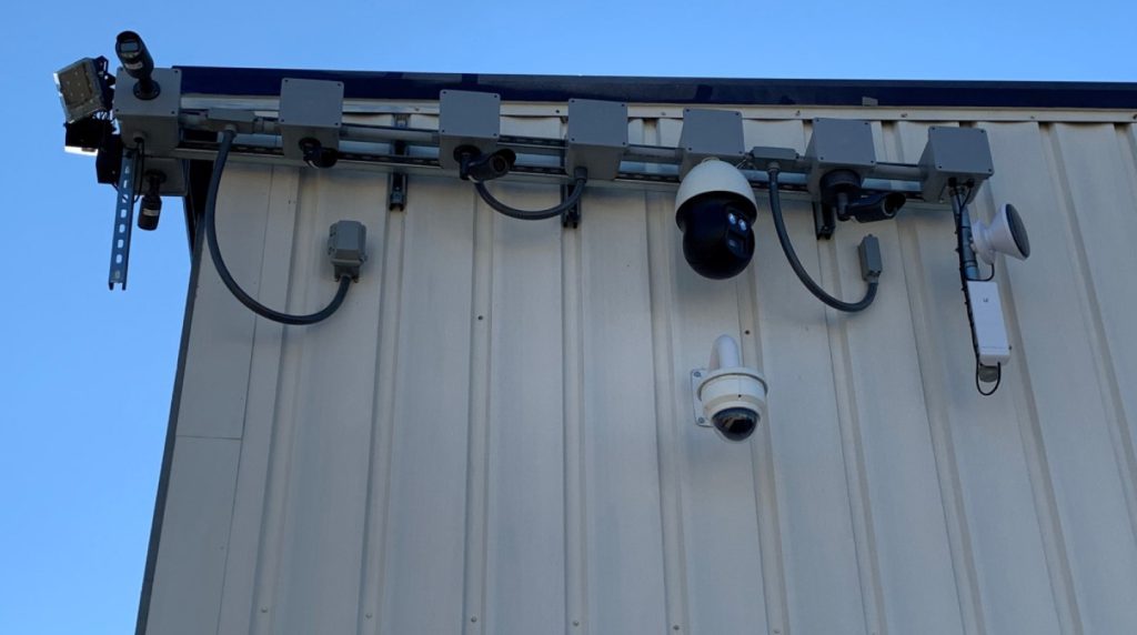 several security cameras are mounted on the side of a building