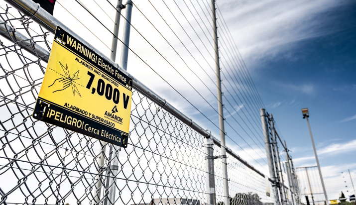 a chain link fence with a warning sign on it