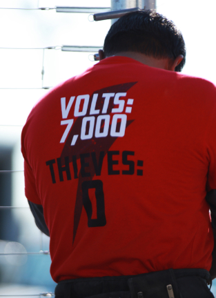 AMAROK employee with shirt that reads "Volts: 7000, Thieves: 0"