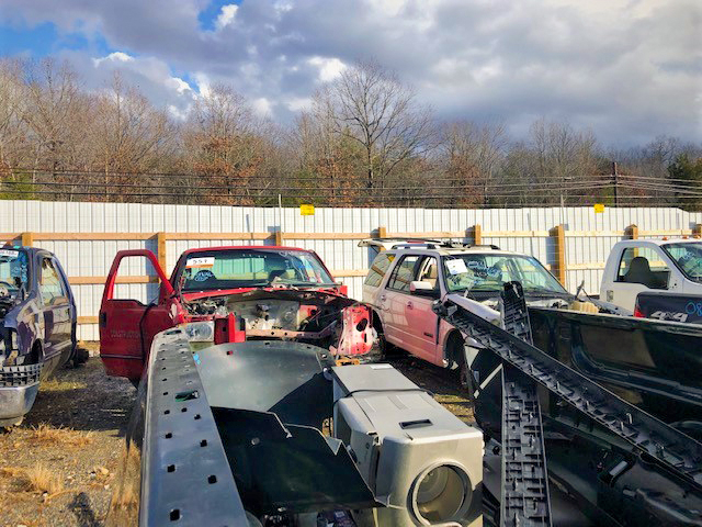 Cars in a Junkyard Surrounded By an Electric Fence