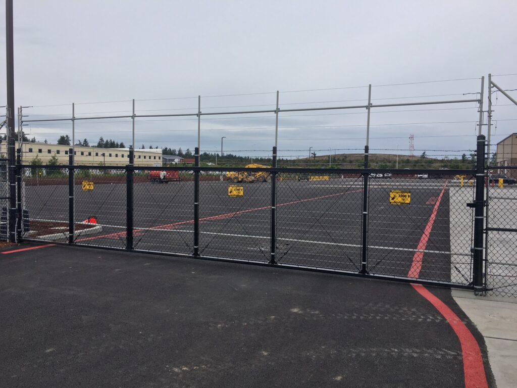 a black chain link fence surrounds a parking lot