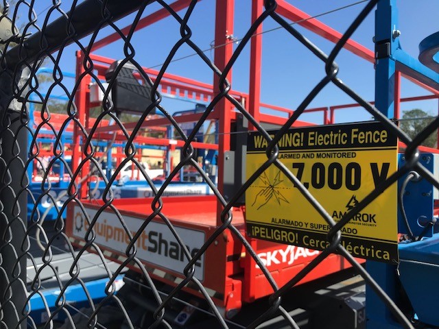 A chain link fence with a sign that says warning electric fence