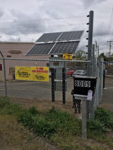 A solar panel sitting on top of an electric fence