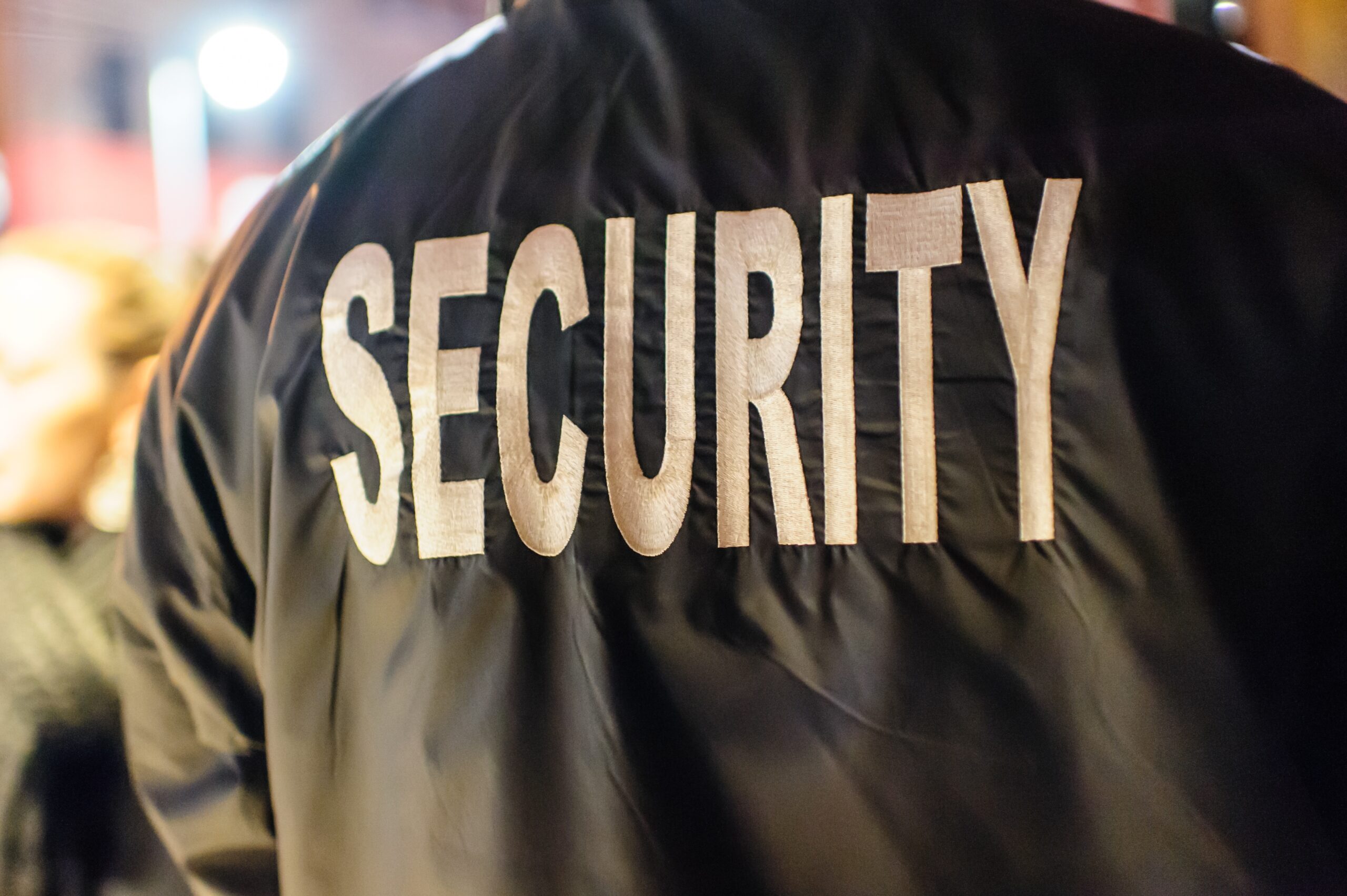 A Security Guard Has the Word Security Embroidered on His Jacket