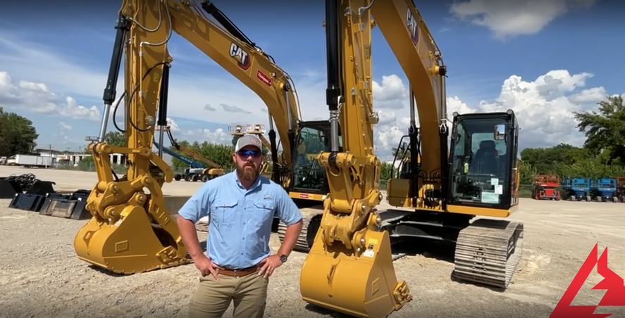 A man stands in front of a cat excavator