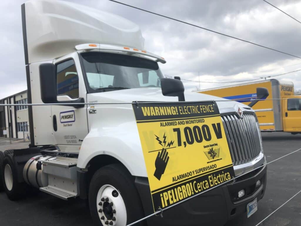 a truck with a warning sign on it that says warning electric fence