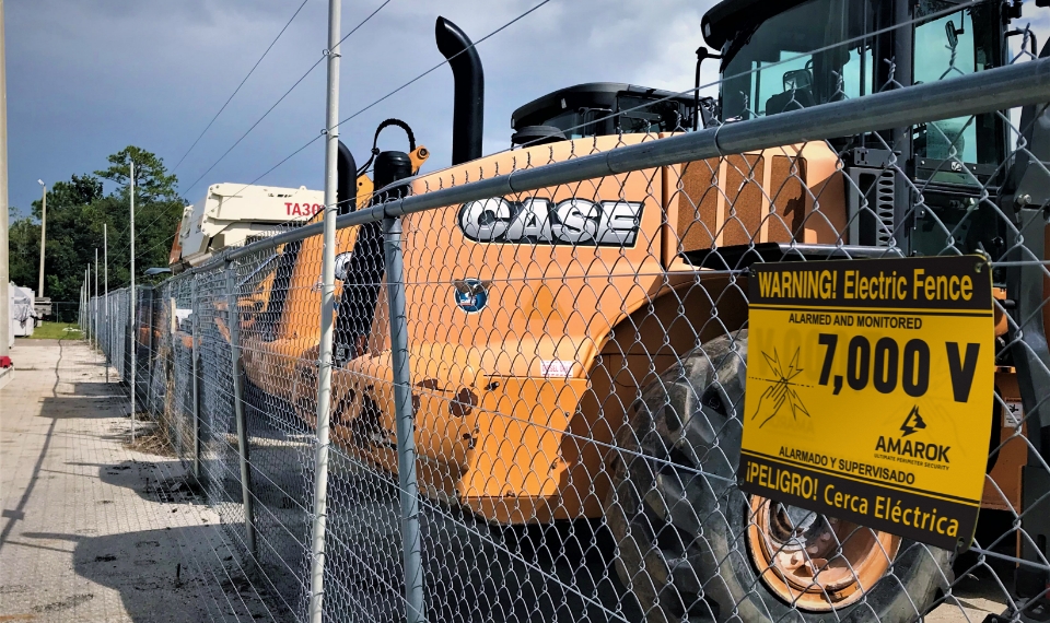 a tractor is behind a chain link fence