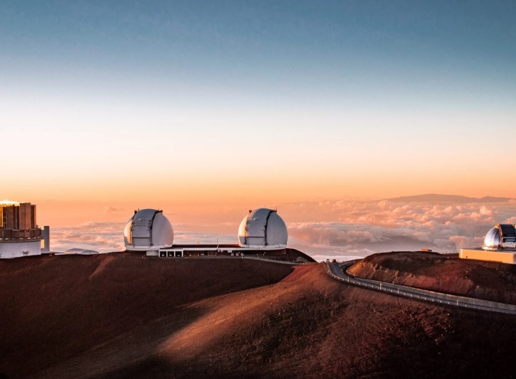 A Large Building on Top of a Hill with a Sunset in the Background