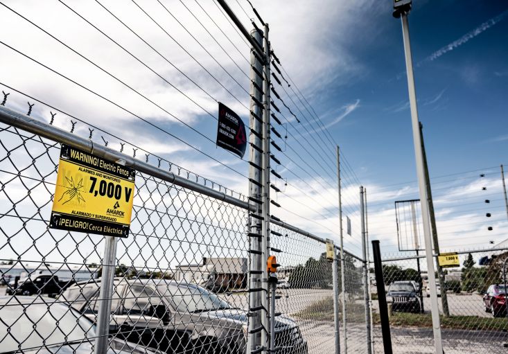 a chain link fence with a sign that says warning electric fence