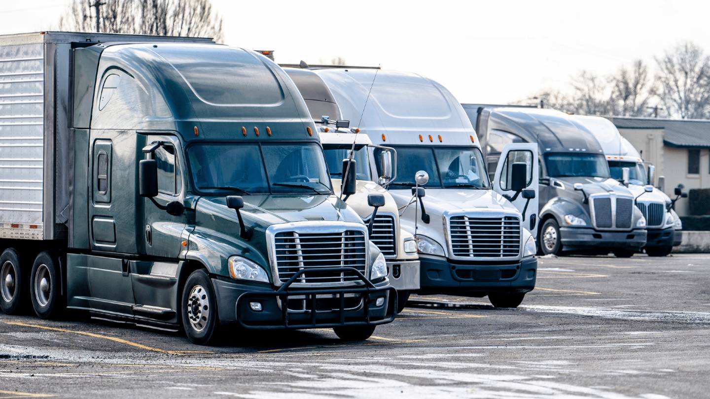 4 semi trucks in a parking lot